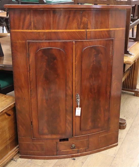 A Regency mahogany bow fronted hanging corner cupboard W.87cm